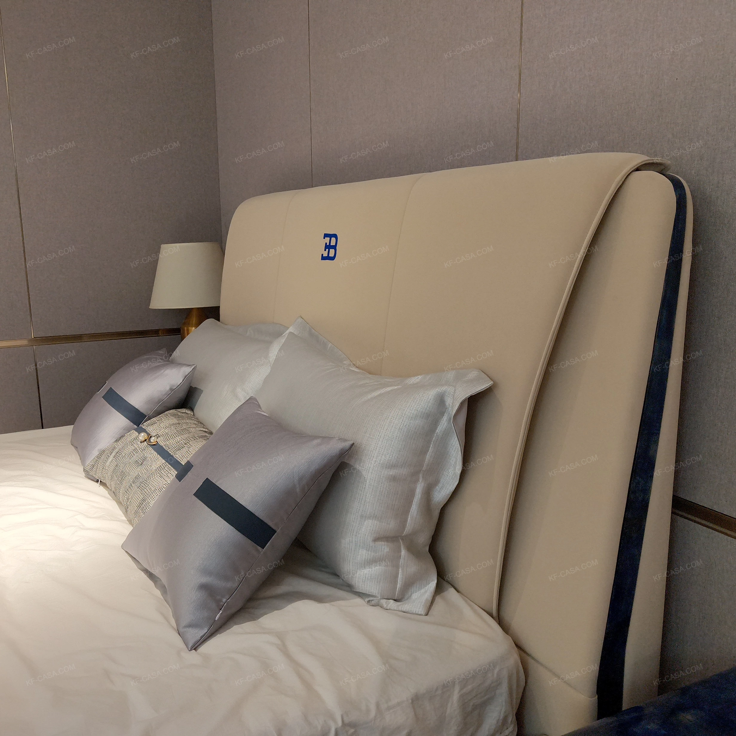 Light Beige Upholstered Bed with Brand Emblem, Navy Accent Stripe & Gold Stainless Steel Feet